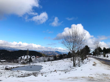 Scenic view of snow covered field against sky