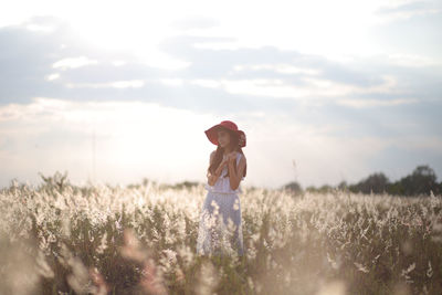 Woman standing on field against sky