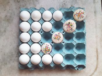 Directly above shot of eggs with cupcakes in crate on table