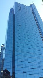 Low angle view of modern building against blue sky