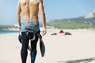 Full length of shirtless man on beach