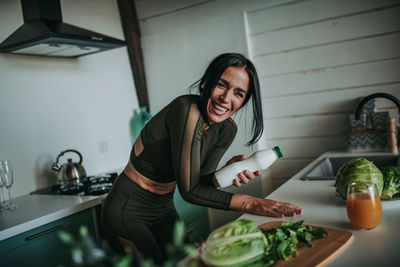 Young woman standing by food at home