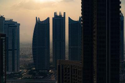 Skyscrapers in city at sunset