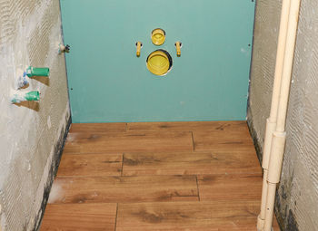 High angle view of yellow lights on floor against blue wall