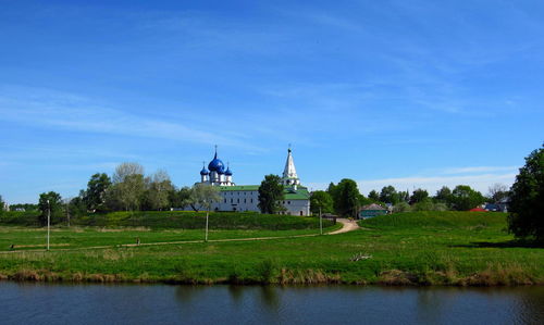 Orthodox church by building against sky.