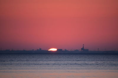 Scenic view of sea against orange sky