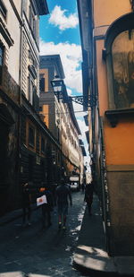 People walking on street amidst buildings in city