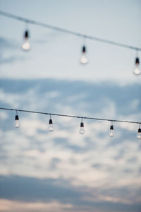 Low angle view of light bulbs against sky