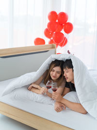 Woman holding balloons at home