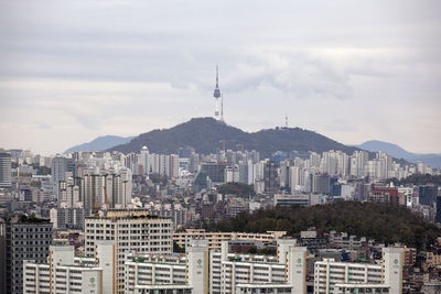 View of cityscape against cloudy sky