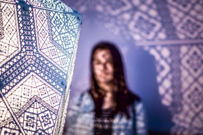 Woman standing by wall