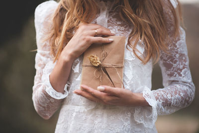 Midsection of woman holding present outdoors