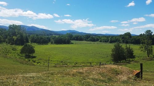 Scenic view of green landscape and mountains against sky