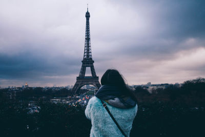 Rear view of woman photographing eiffel tower