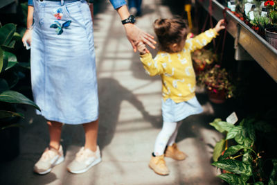 Mother and daughter holding hands in greenhouse