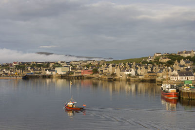 Boats moored on river against sky