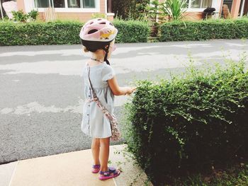 Full length of young woman standing against tree