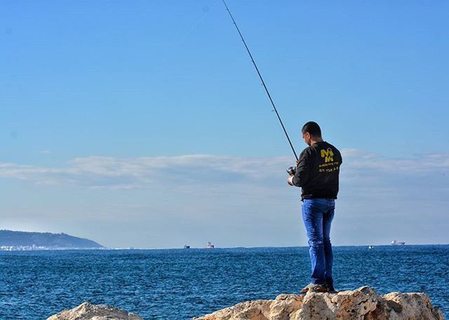 sea, water, lifestyles, horizon over water, leisure activity, standing, full length, sky, young adult, casual clothing, tranquility, three quarter length, scenics, nature, blue, beauty in nature, tranquil scene, vacations