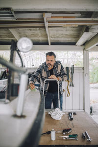 Mature man cleaning speedboat in garage