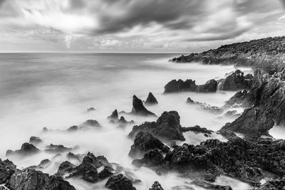 Scenic view of sea against cloudy sky