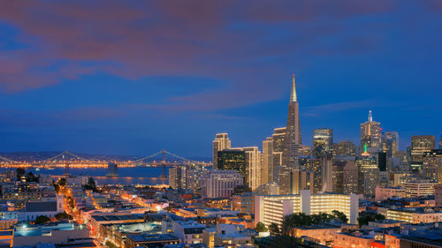 Illuminated cityscape against sky