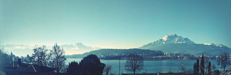 Panoramic shot of buildings and mountains against clear sky