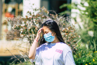 Portrait of woman standing against plants