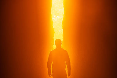 Rear view of silhouette man standing at sunset