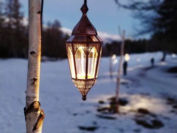 Close-up of illuminated street light against sky during winter