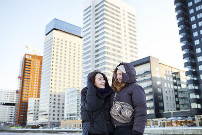 Young female couple hugging in modern neighborhood