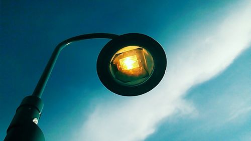 Low angle view of illuminated street light against blue sky