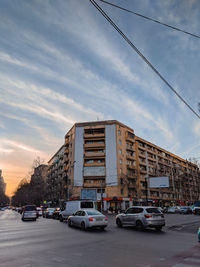 Traffic on road by buildings against sky