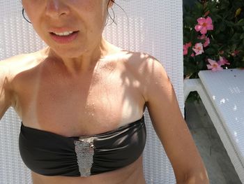 Midsection of woman standing by swimming pool