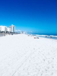 Scenic view of beach against clear blue sky