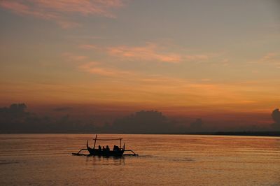 Boats in sea at sunset