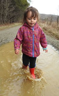 Cute girl standing in puddle