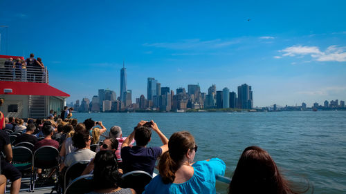 People at modern buildings in city against sky