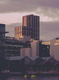 Modern buildings against sky during sunset