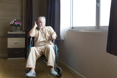 Portrait of man sitting on chair at home