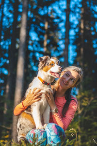 Portrait of a young female athlete with her running and hiking partner, an australian shepherd dog