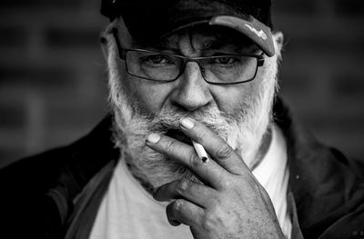 Portrait of man smoking cigarette outdoors