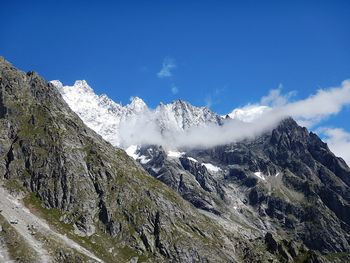 Low angle view of mountains against blue sky