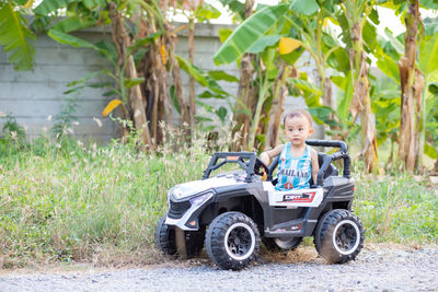 Portrait of boy and car on plants