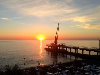 Silhouette pier over sea against sky during sunset