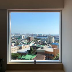 High angle view of buildings against sky seen through window