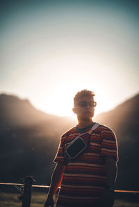 Portrait of man standing against sky during sunset