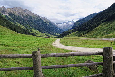 Footpath amidst field against mountains