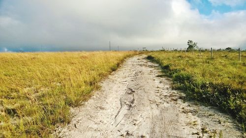 Dirt road along countryside landscape