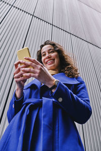 Smiling young woman using mobile phone