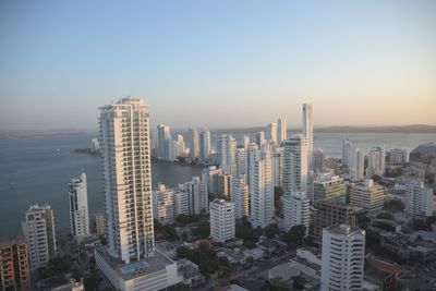 Aerial view of buildings in city against clear sky